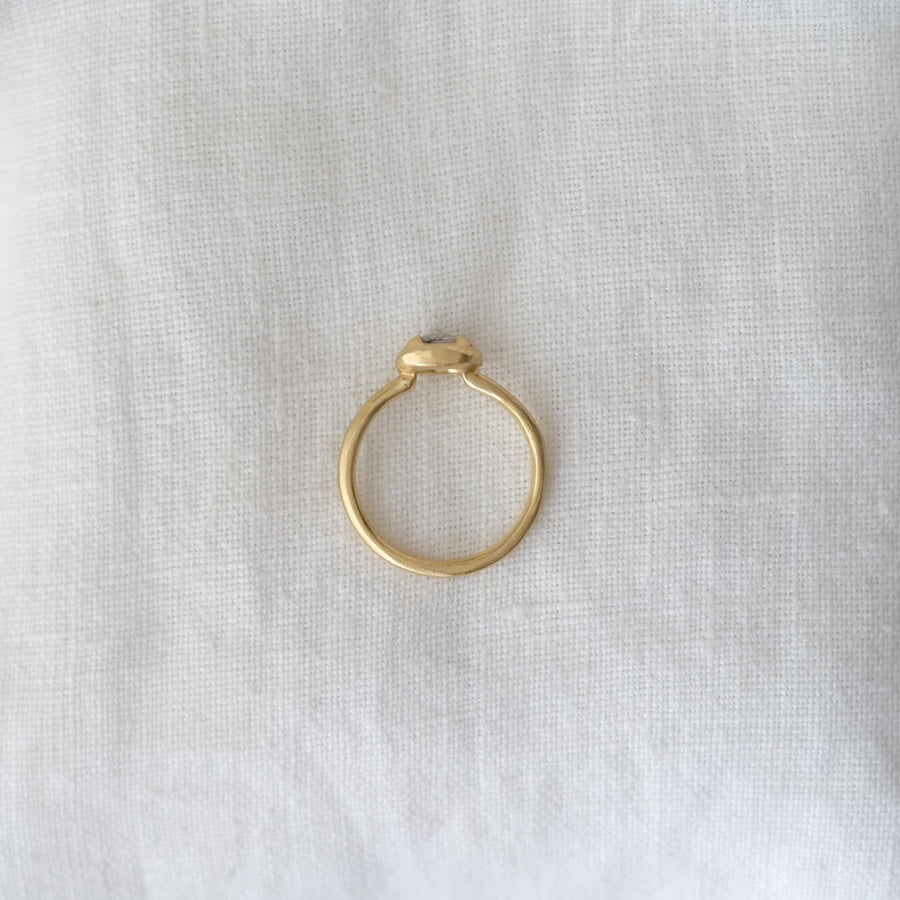 Gold ring on a light gray fabric background