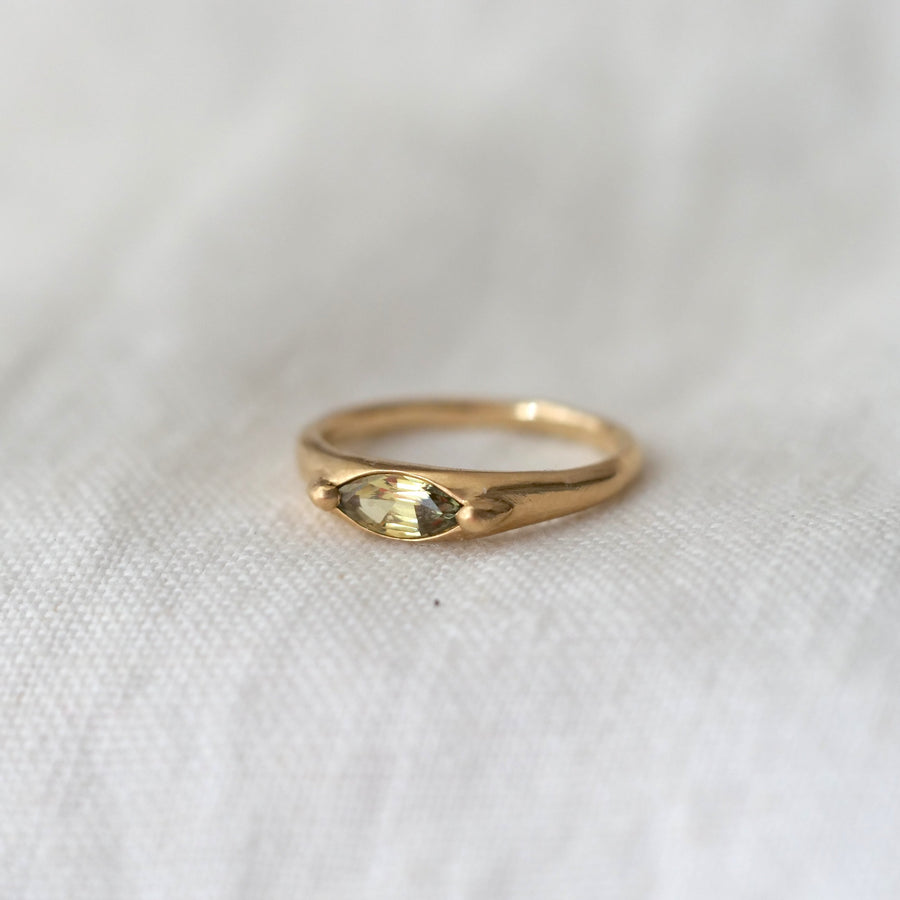 Gold ring with a diamond on a white fabric background