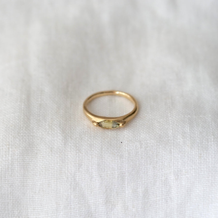 Gold ring with a gemstone on a white fabric background