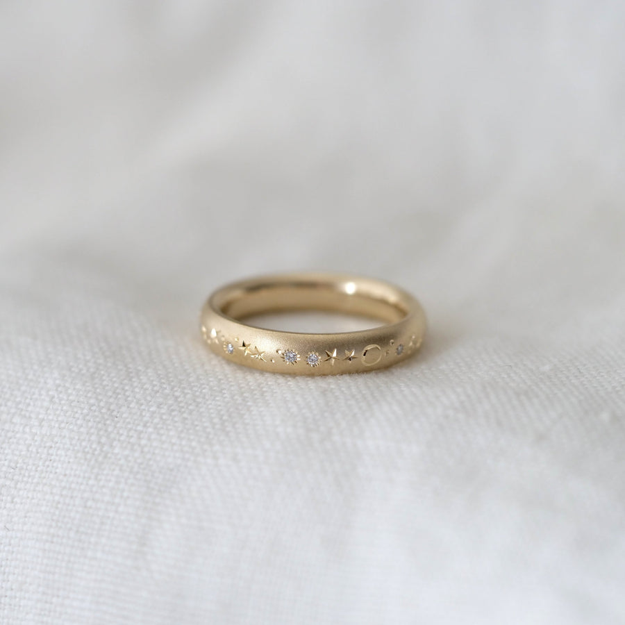 Gold ring with small stones on a white fabric background