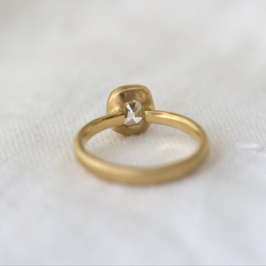 Gold ring with a diamond on a white fabric background