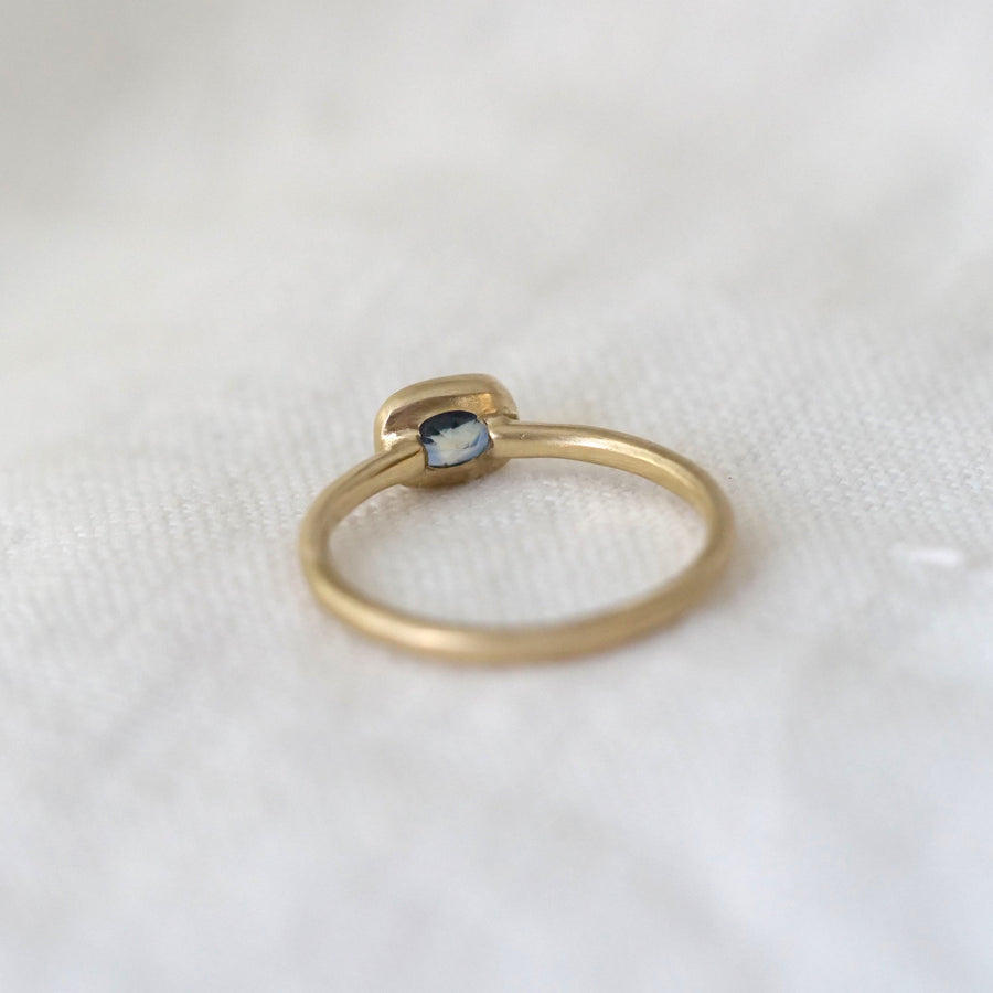 Gold ring with a gemstone on a white fabric background