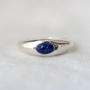 Silver ring with a blue gemstone on a white background