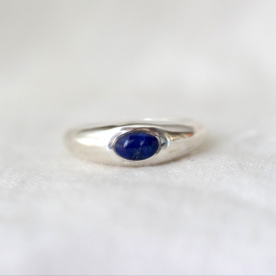 Silver ring with a blue gemstone on a white background