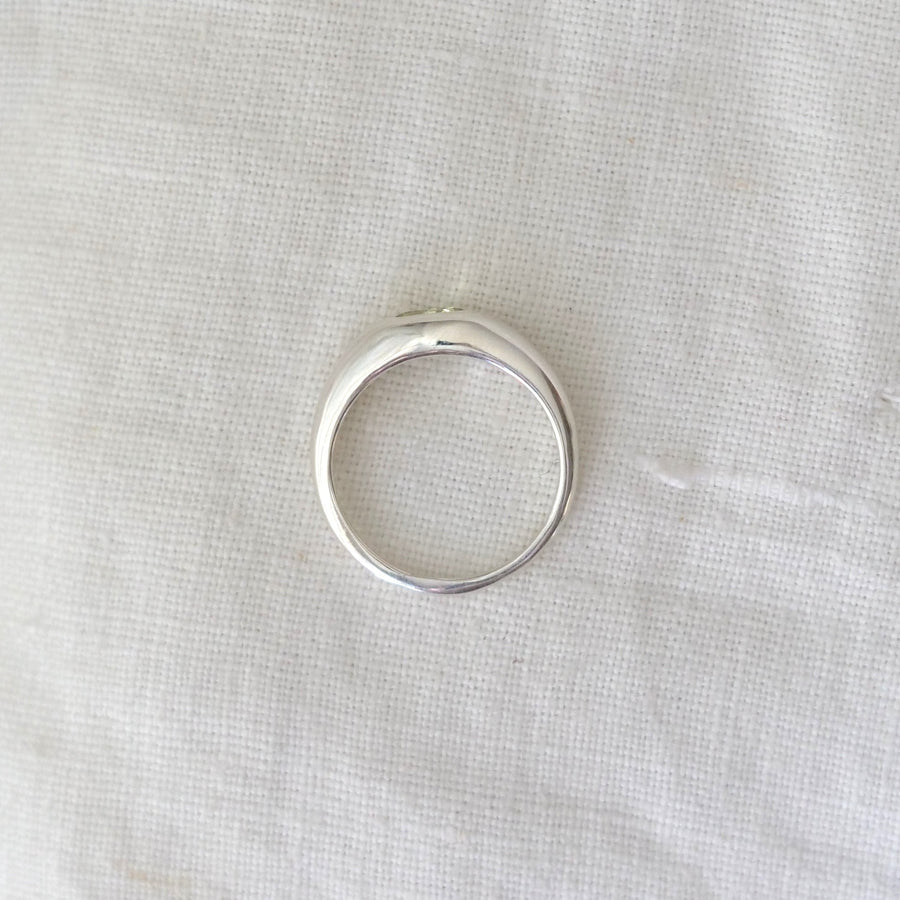 Silver ring on a white fabric background