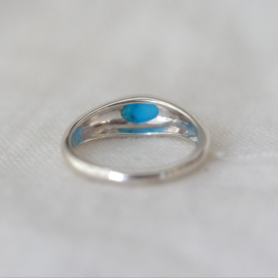 Silver ring with a blue stone on a white background
