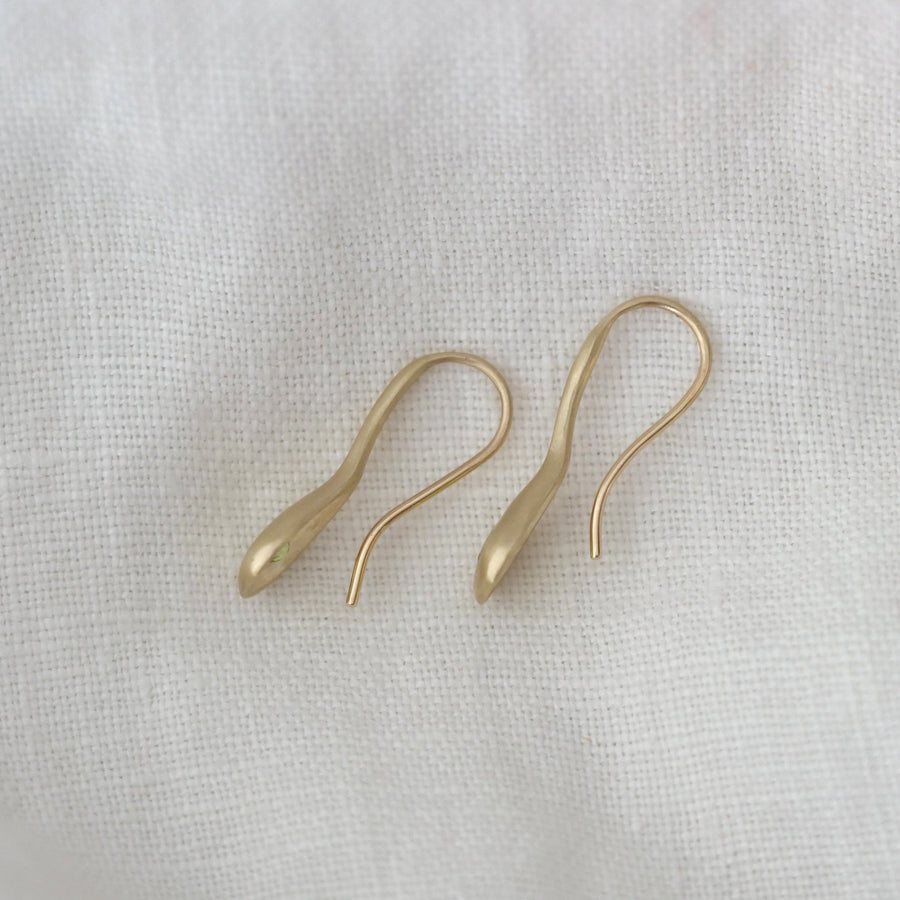 Pair of gold earrings on a light fabric background