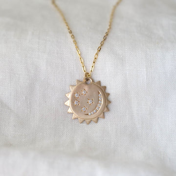 14k yellow gold pendant with a diamond crescent moon and diamond stars, on a 14k gold chain.