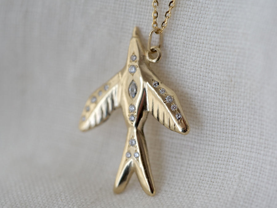 Gold necklace with a unique pendant on a light gray background