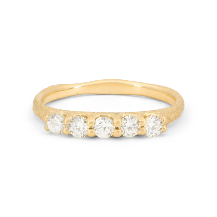 18k yellow gold band features 5 round recycled white diamonds set together across the front of a hand engraved sand textured