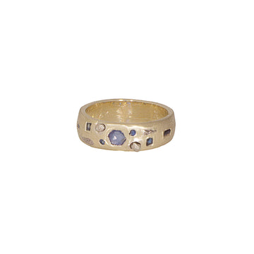 Gold ring with embedded blue sapphires stones and white gold, on a white background