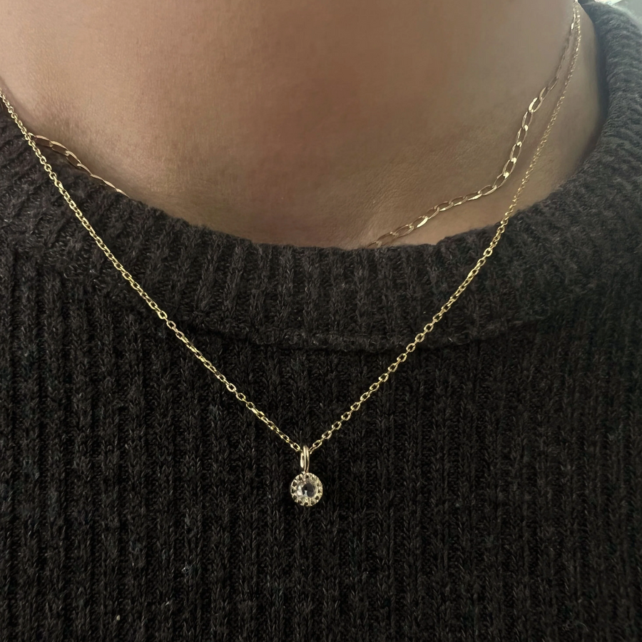 a single rose cut diamond suspended from a delicate cable chain on model
