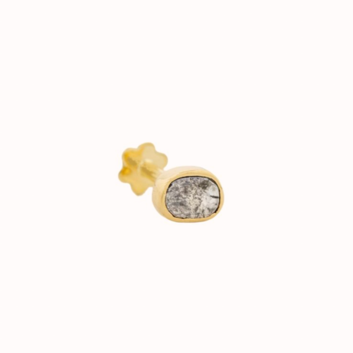 GOLD PIERCING WITH A ONE OF A KIND GREY DIAMOND . THE STONE COMES IN A GRADIENT OF WHITE AND DARK GREY