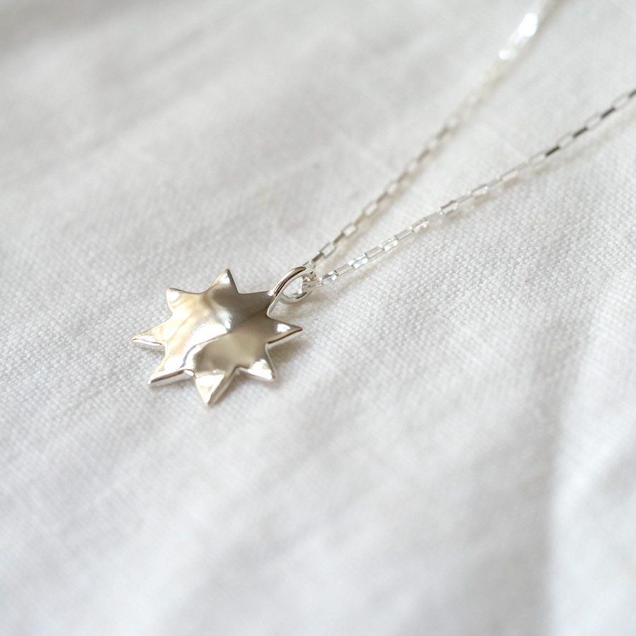 this delicate pendant has a domed center and 9 points, making it the perfect everyday piece