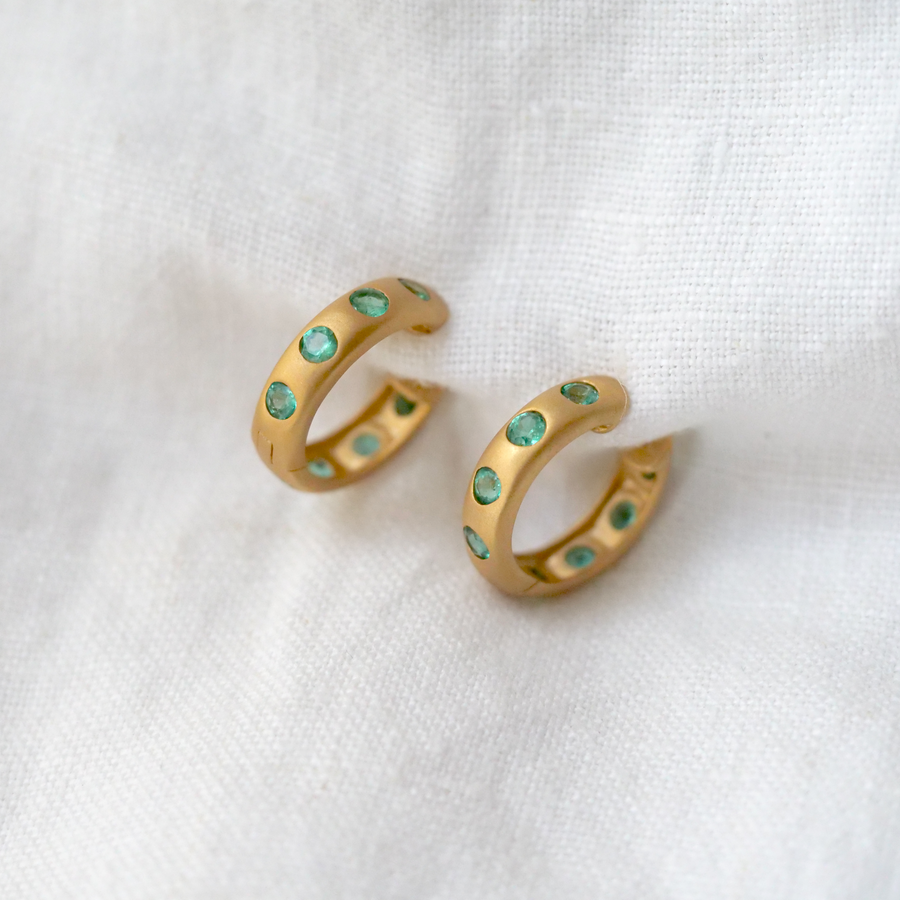 Gorgeous chunky 14k yellow gold clicker hoops with 8 emeralds per earring. Dimensions: 17.5mm x 4.8mm. Sold as a pair. 