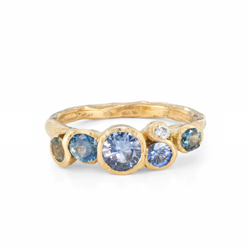 Pools of ocean blue sapphires are enveloped in ribbons of sea worn gold. A sea inspired treasure that glitters with the light of cool, clear pools.