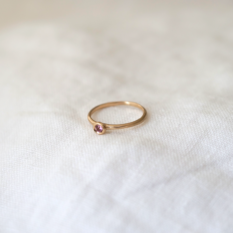 A lightweight 14k gold band with a gorgeous 2.5mm Brilliant Cut Light Pink Sapphire bezel set ring Marisa Mason