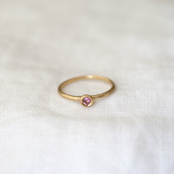A lightweight 14k gold band with a gorgeous 2.5mm Brilliant Cut Light Pink Sapphire bezel set ring Marisa Mason