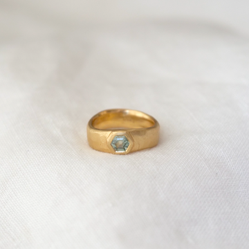 A playfully organic band, made especially to fit a gorgeous and unique light seafoam-green hexagonal Montana Sapphire. Set in 18K gold with plenty of texture and wave, this piece is truly one-of-a-kind.