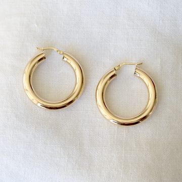 5mm thick, hollow hoops in 14k solid gold with hinge clasp, on white linen background