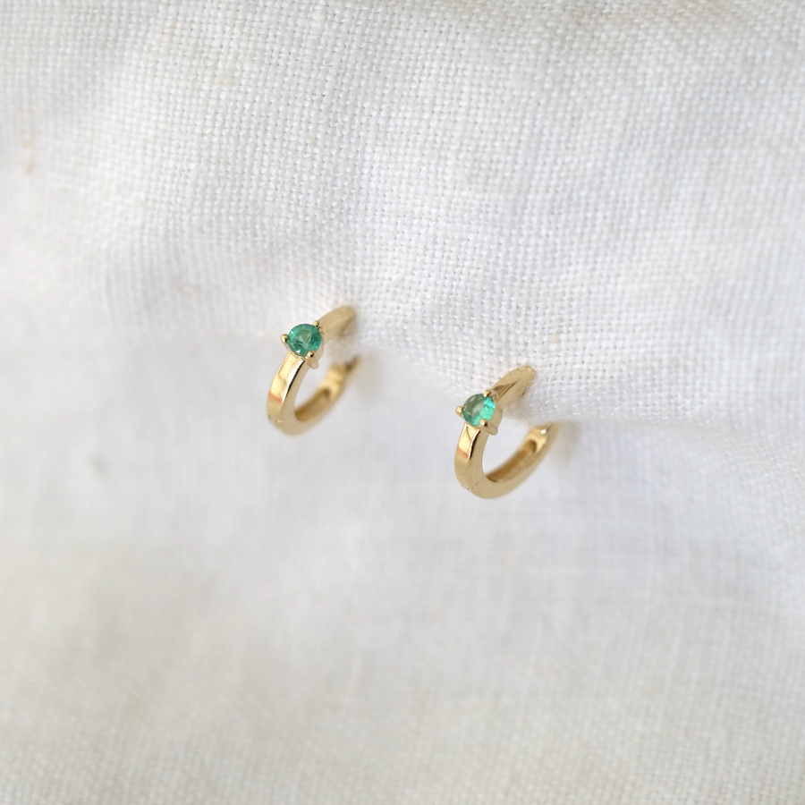 emeralds are securely prong set in the center of these wide hoops, making them sit closer to the lobe