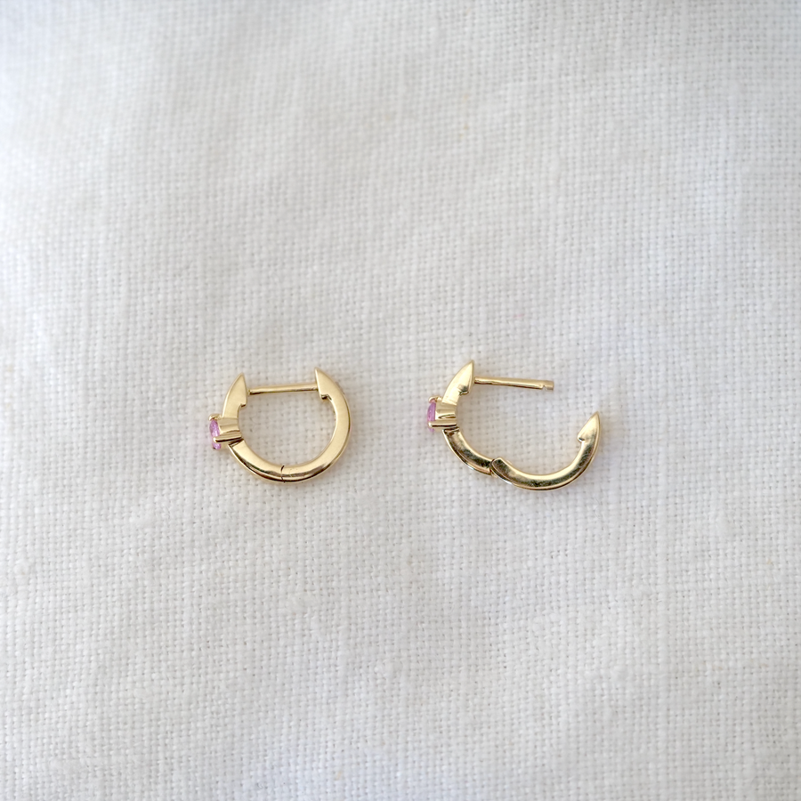 Pink sapphires are securely prong set in the center of these wide gold hoops, making them sit closer to the lobe