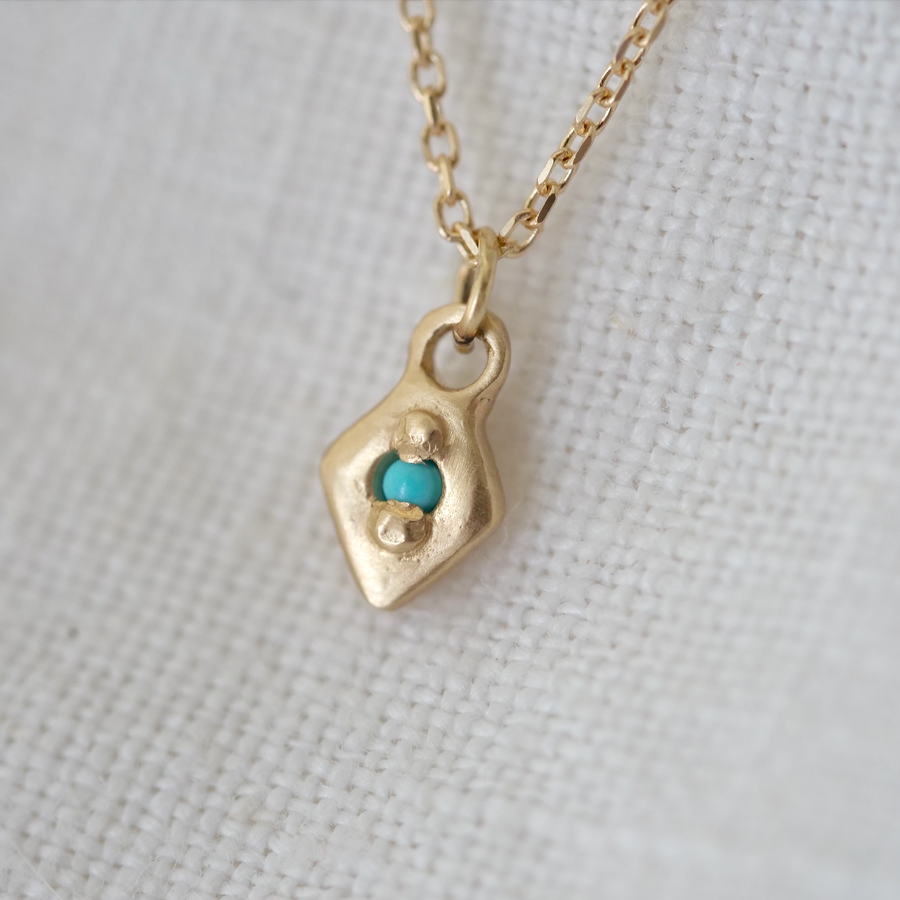 Delicate 14k gold diamond shaped pendent, bead-set with a white diamond or turquoise point. 