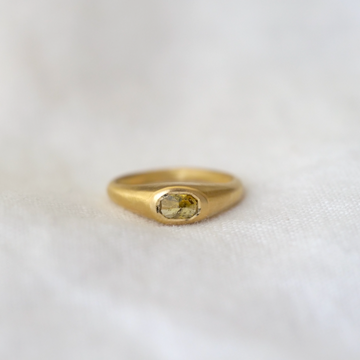 Mossy colored rose cut oval diamond bezel set in a domed and tapered band 