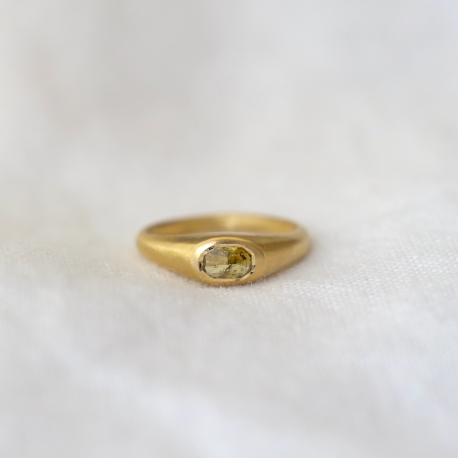 Mossy colored rose cut oval diamond bezel set in a domed and tapered band 