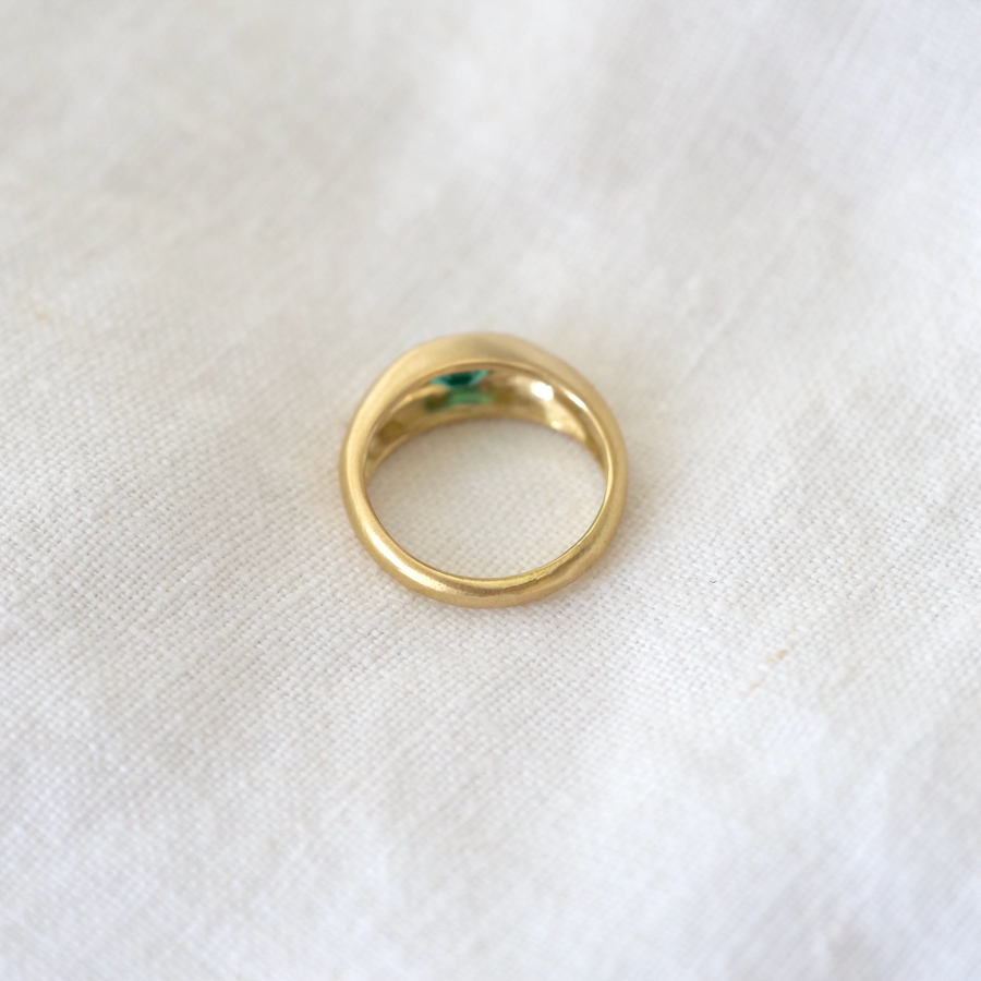 Oval emerald bezel set in 18k gold domed band