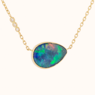 14k light yellow gold chain necklace with a pendant set with one opal and three diamonds. This stone has a brilliant assortment of color flash and has delightful blue to green flashes.