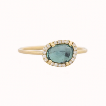 14K LIGHT YELLOW GOLD RING WITH A BLUE TOURMALINE SURROUNDED BY DIAMONDS. THE STONE COMES IN A GRADIENT OF BLUE.