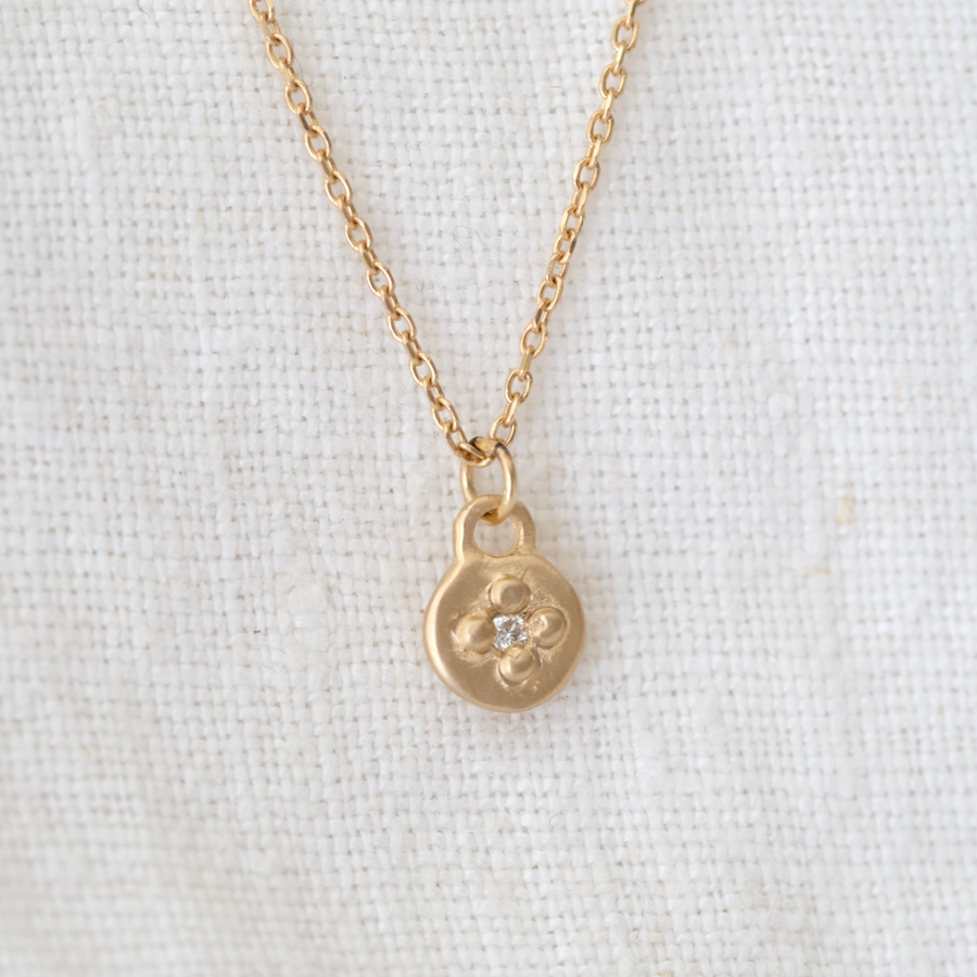 Delicate 14k gold circle pendent, bead-set with a white diamond