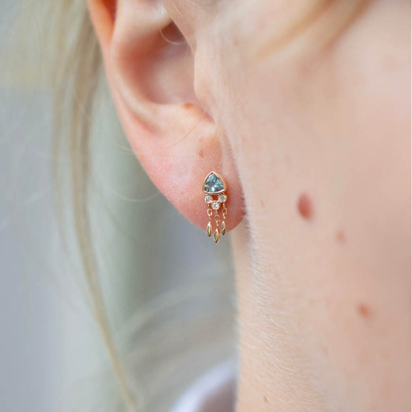 14K LIGHT YELLOW GOLD EARRING WITH ONE DARK BLUE AQUAMARINE, DIAMONDS AND DANGLING DETAILS.