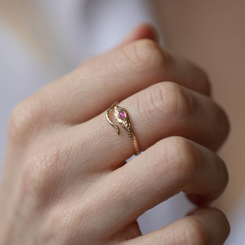 Gold Cobra Ring wraps around the finger, with the end of the tail meeting the head with its two white diamonds as eye and one ruby on its head. 