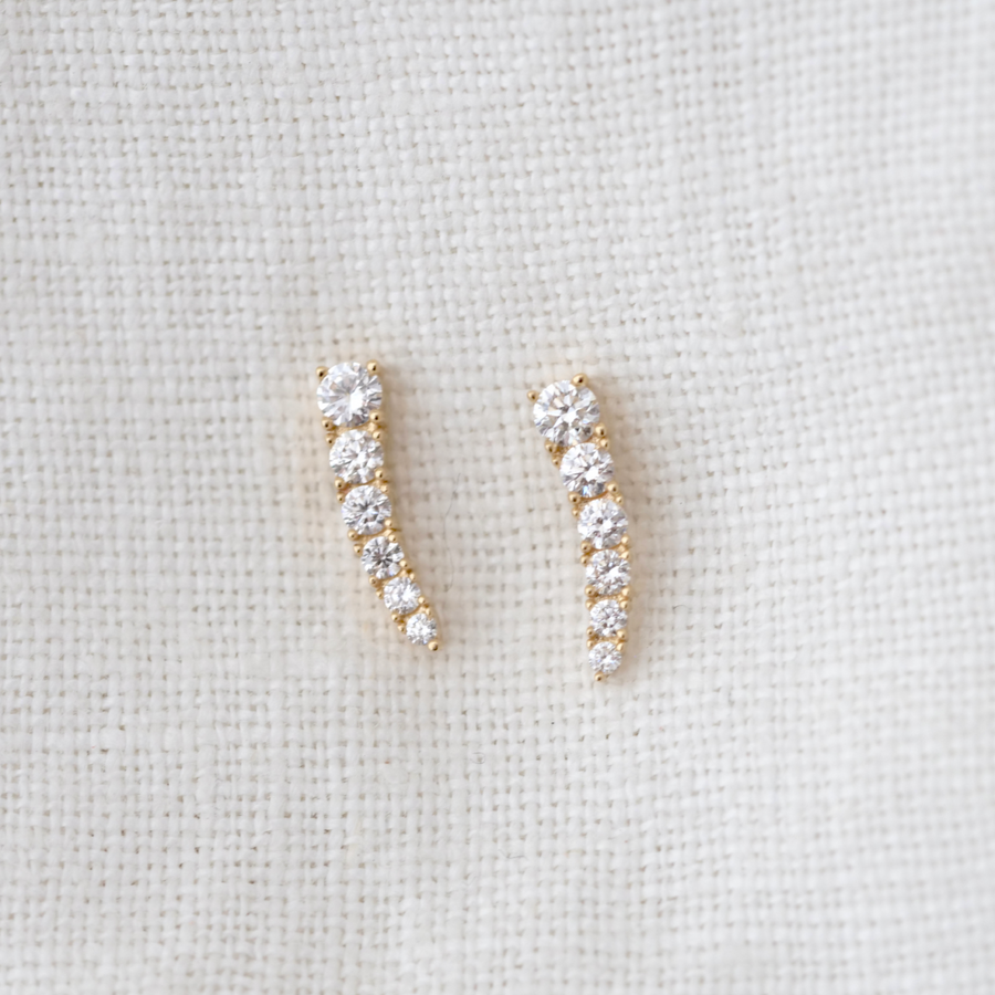 With 6 white diamonds on each stud, these earrings graduate in size and curve to a point for a unique and eye-catching look