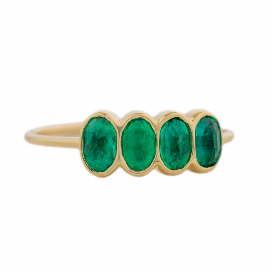 Four oval shaped emeralds bezel set on a thin glad band