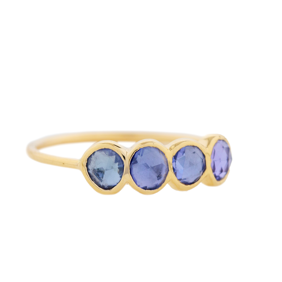 Four light blue tanzanite bezel set on a think gold band