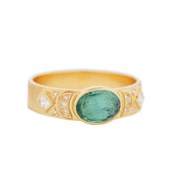 round green tourmaline stone bezel set in wide gold band with crescent shapes and white diamonds on either side 