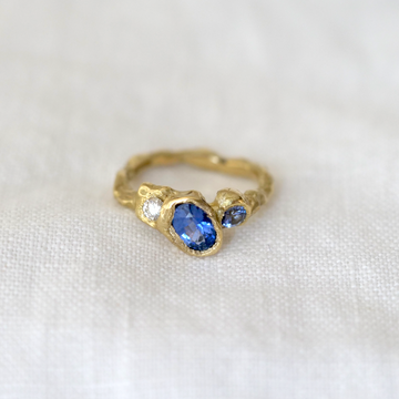 Two blue sapphires and one white diamond set in organically carved 18K gold.