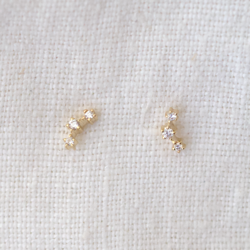 3 White diamonds are set along a slight curve, prong set in 14k gold