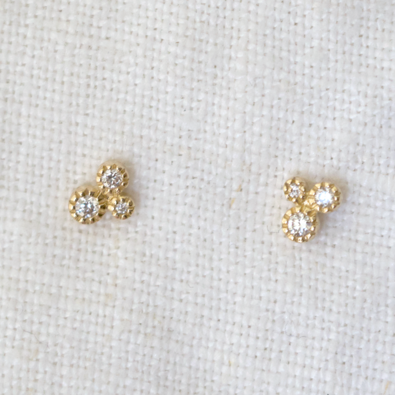 three dazzling bezel set diamonds and delicate milgrain detailing in 14k gold