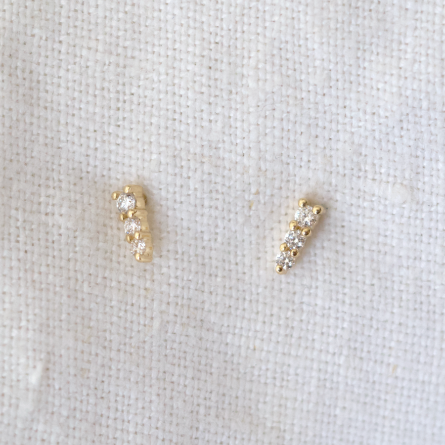 Three white diamonds graduating in small to large, prong set on gold studs