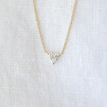 Three white diamonds prong set in the shape of a triangle, on a delicate gold chain 