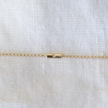 14 karat gold bar bracelet, adorned with a dazzling diamond on delicate chain