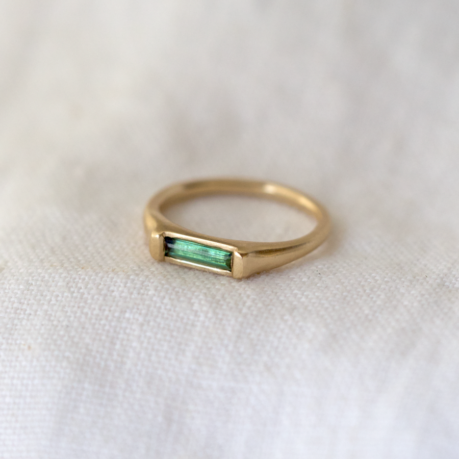 14k gold band with flat surface, inset with a long green tourmaline bar