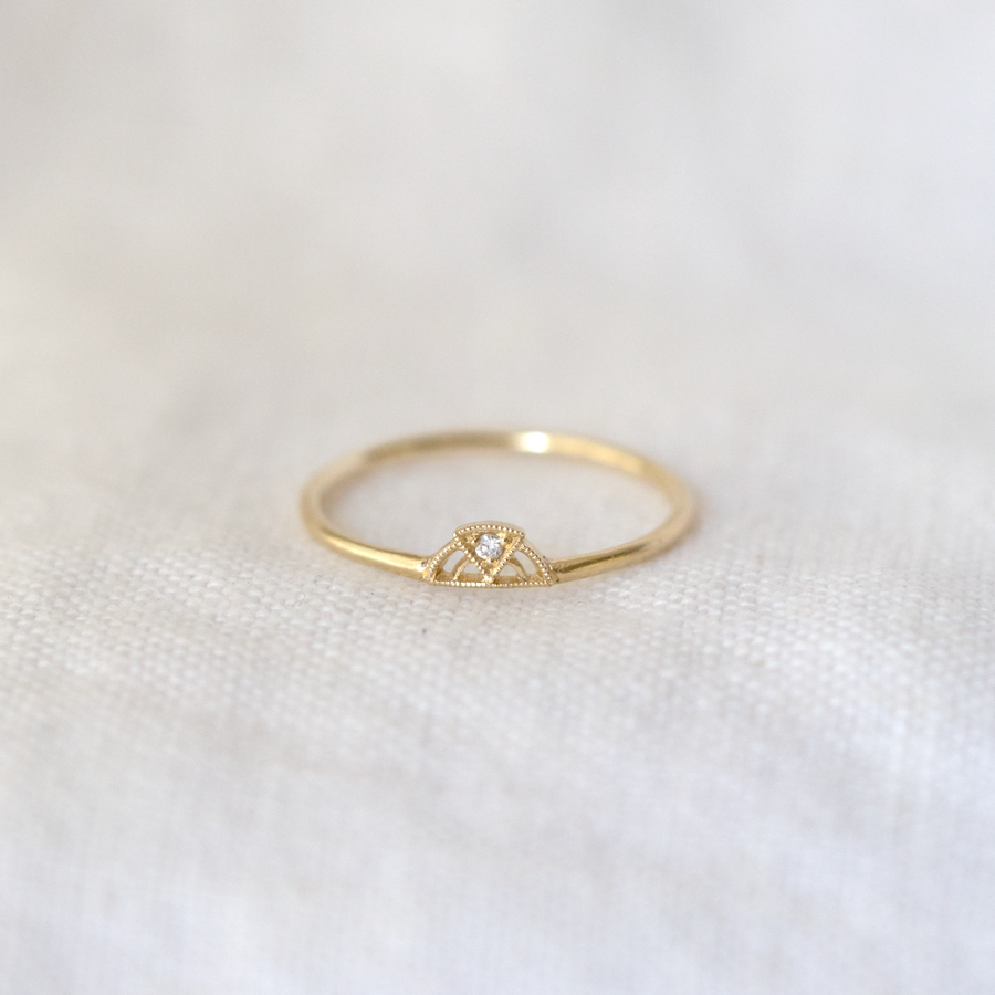 thin gold band with arch cut out with triangle of gold, with a white diamond at the center