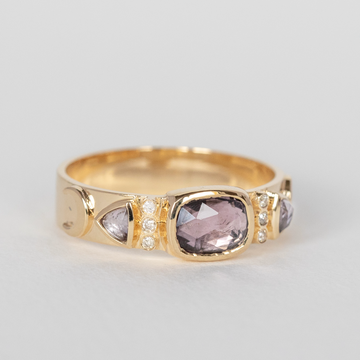 14k gold band with three large purple-grey tourmalines, with white diamonds and moon embellishments on the side.