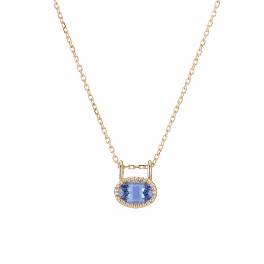 Oval blue sapphire set in milgran gold setting , on a delicate gold chain 