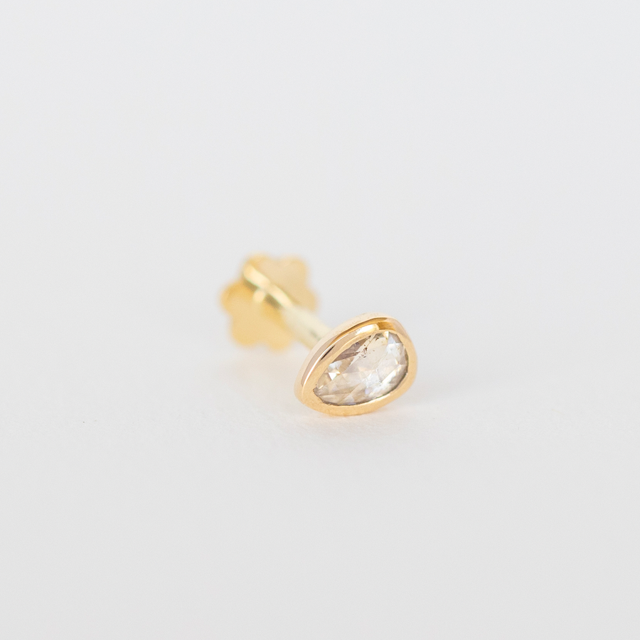 14K LIGHT YELLOW GOLD PIERCING WITH A ONE OF A KIND GREY DIAMOND . THE STONE COMES IN A GRADIENT OF WHITE AND DARK GREY